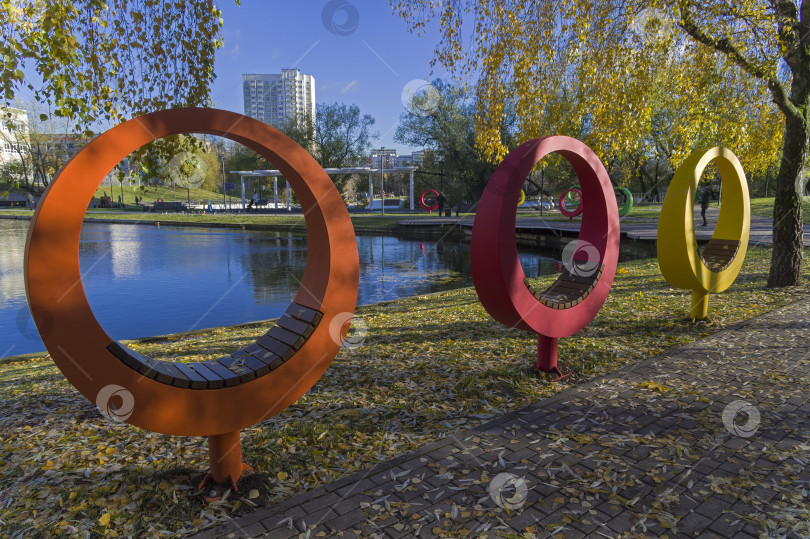 Скачать Скамейки оригинальной круглой формы на берегу пруда. фотосток Ozero