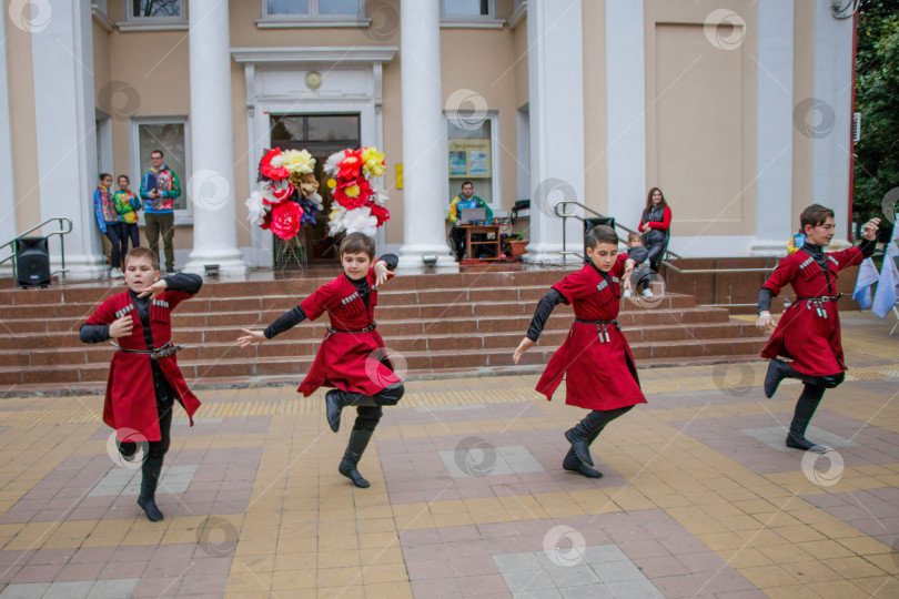 Скачать Детский самодеятельный коллектив танцует кавказский танец лезгинку на городской площади. фотосток Ozero