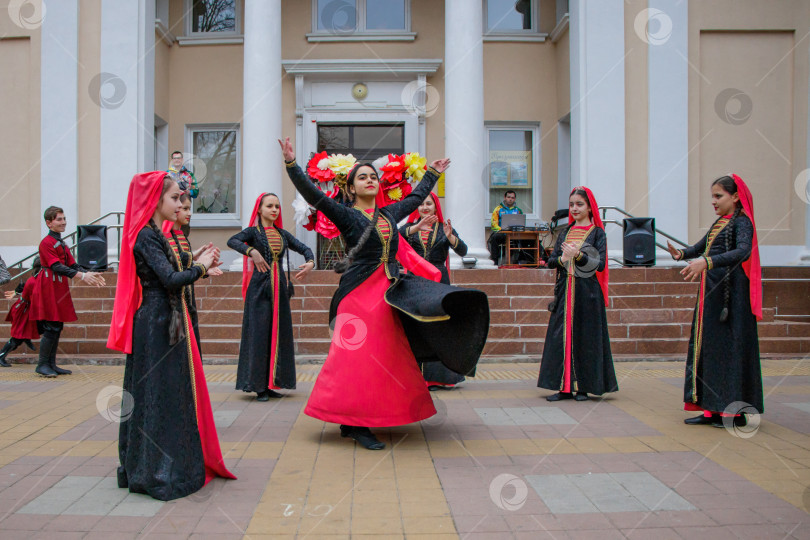 Скачать Детский самодеятельный коллектив танцует зажигательный кавказский танец лезгинку на городской площади. фотосток Ozero