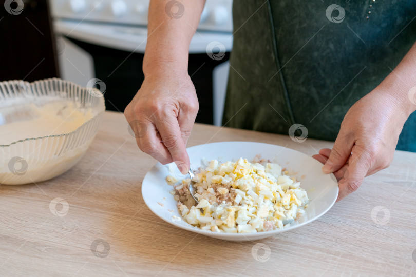 Скачать Женщина готовит блюдо с яйцами и сыром фотосток Ozero