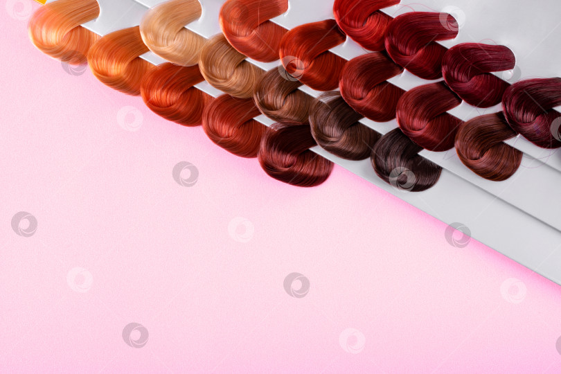 Скачать Палитра с образцами краски для волос разных цветов на розовом фоне. Окрашивание волос в различные оттенки в парикмахерской. фотосток Ozero