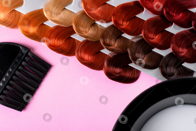 Скачать Профессиональный парикмахер ровно лежал. Образцы краски для волос разных цветов, кисточка-аппликатор и краска в чаше для смешивания оттенков на розовом фоне. Окрашивание волос в различные оттенки. фотосток Ozero