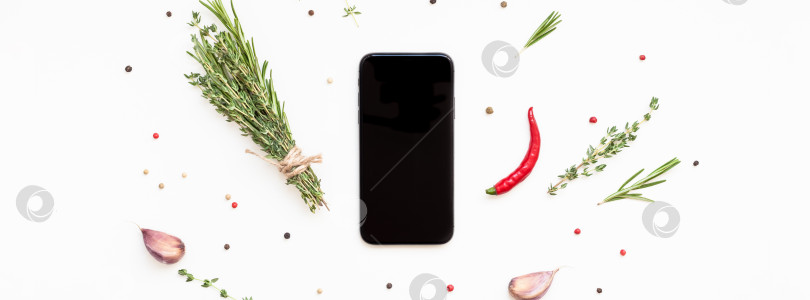 Скачать Смартфон с зеленью и пряностями вокруг фотосток Ozero