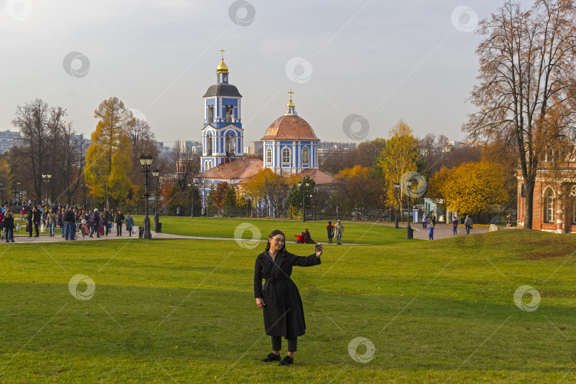 Скачать Девушка делает селфи в осеннем парке. фотосток Ozero