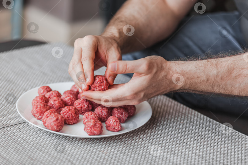 Скачать Человек своими руками готовит фрикадельки с сырым мясным фаршем фотосток Ozero