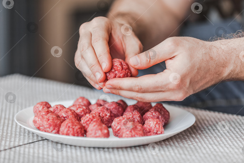 Скачать Человек своими руками готовит фрикадельки с сырым мясным фаршем фотосток Ozero