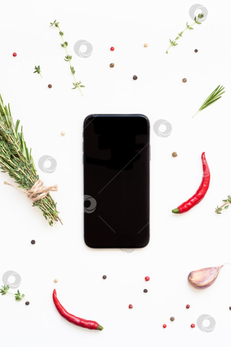 Скачать Смартфон с зеленью и пряностями вокруг фотосток Ozero