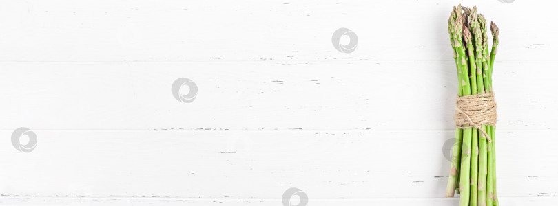 Скачать Свежая зеленая спаржа на белом деревянном фоне фотосток Ozero