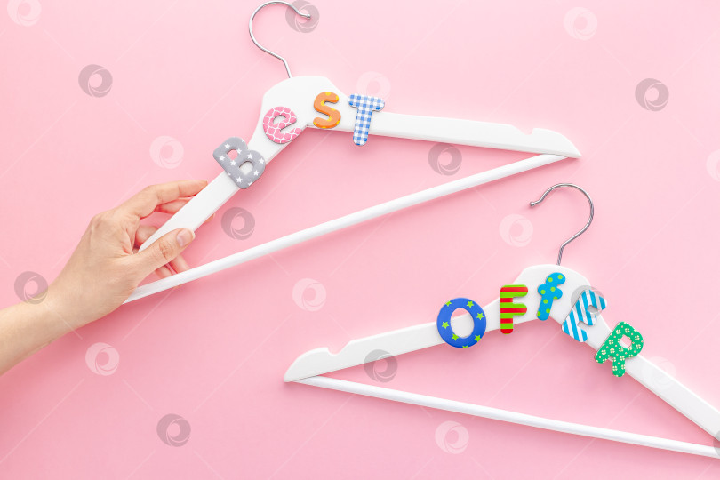 Скачать Белые вешалки с рекламным текстом на розовом фоне фотосток Ozero