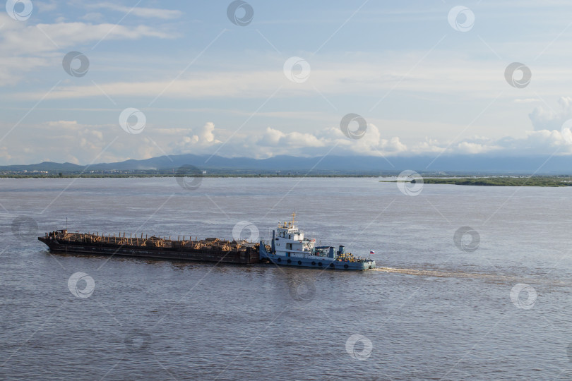 Скачать На реке Амур буксир толкает баржу с лесом фотосток Ozero