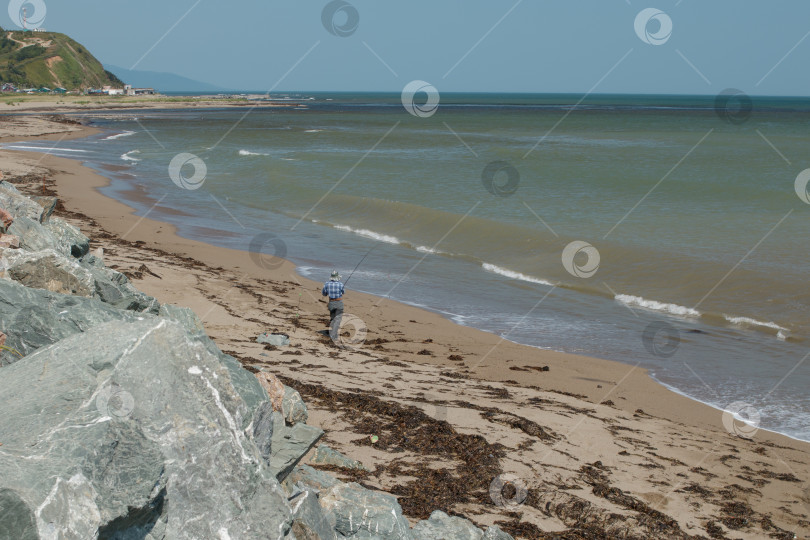 Скачать Рыбак ловит рыбу в море фотосток Ozero