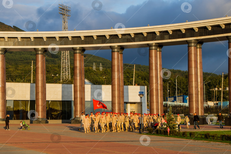 Скачать Отряд молодых армейцев в военной форме с флагом стоит на площади Победы. Южно-Сахалинск, Россия фотосток Ozero