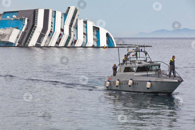 Скачать ДЖИЛЬО, ИТАЛИЯ - 28 апреля 2012 г.: Круизный лайнер Costa Concordia у побережья итальянского острова Джильо после кораблекрушения, произошедшего 13 января 2012 г. фотосток Ozero