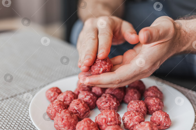 Скачать Человек своими руками готовит фрикадельки с сырым мясным фаршем фотосток Ozero