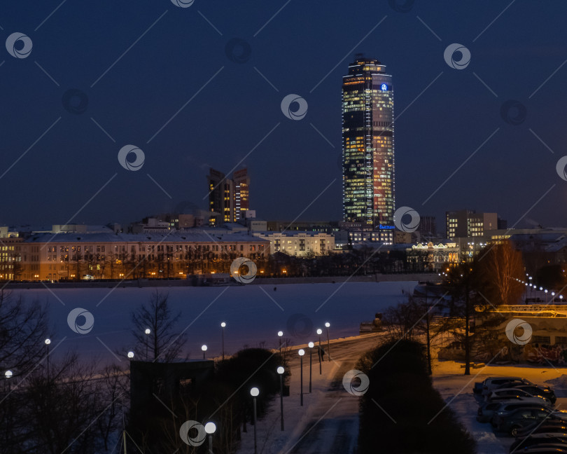 Скачать Ночной пейзаж зимнего города Екатеринбурга. Вид на реку Исеть и башню Высоцкого. фотосток Ozero