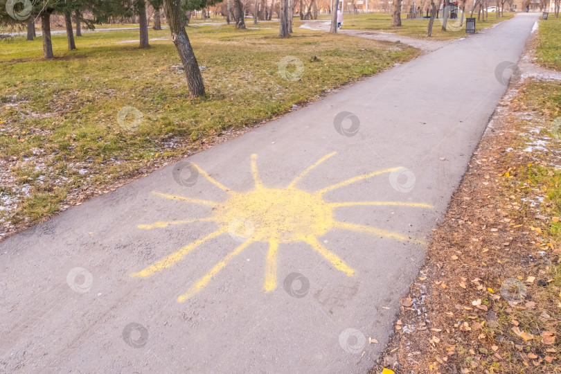 Скачать Солнце с лучами, нарисованными желтым мелом на асфальте фотосток Ozero