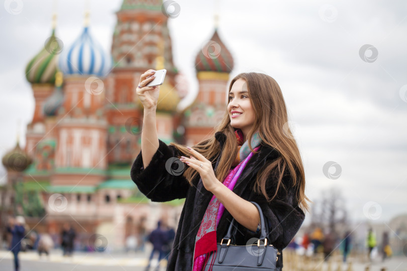 Скачать Молодая красивая туристка фотографирует на мобильный телефон фотосток Ozero