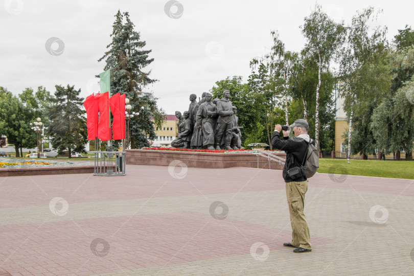 Скачать Турист с рюкзаком снимает любительское видео на площади Победы в Витебске, Беларусь фотосток Ozero