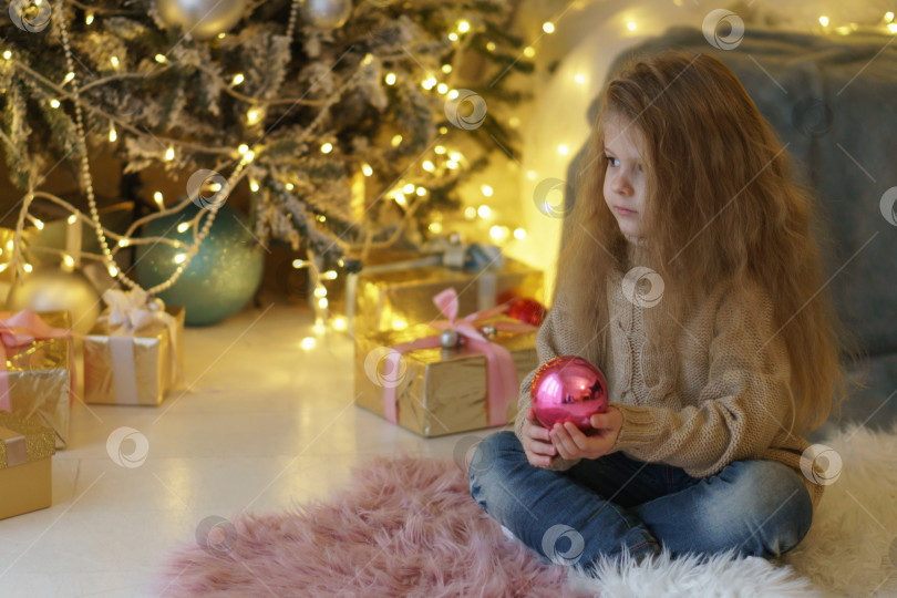 Скачать Маленькая девочка с рождественской игрушкой. фотосток Ozero