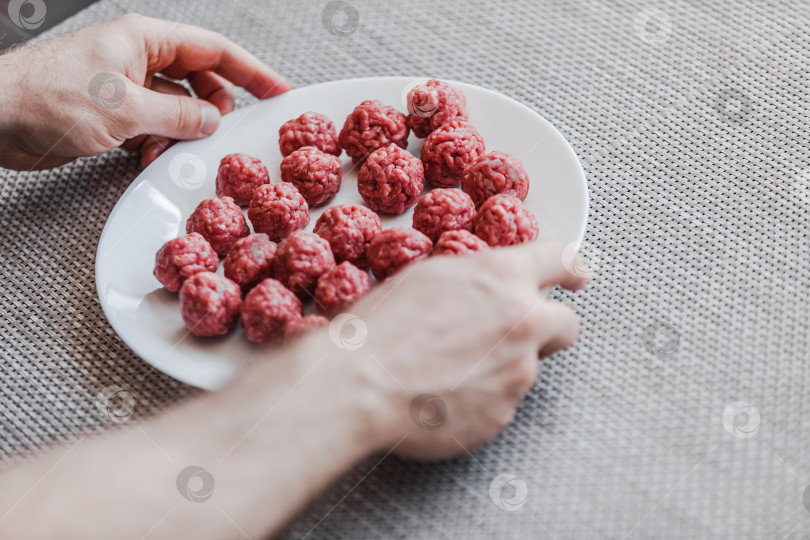 Скачать Человек своими руками готовит фрикадельки с сырым мясным фаршем фотосток Ozero