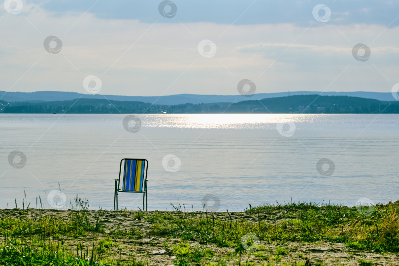 Скачать Шезлонг одиноко стоит на берегу озера. фотосток Ozero