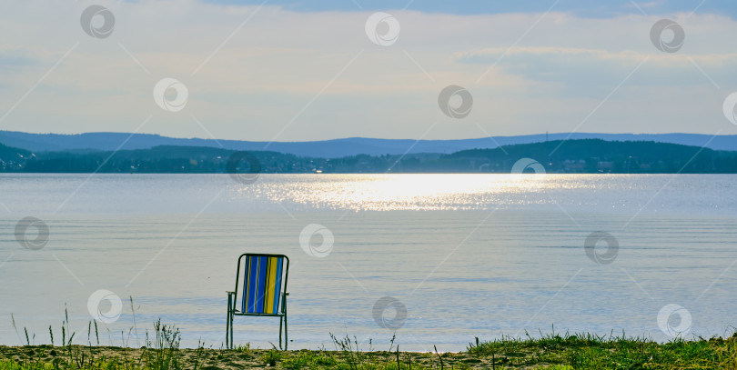 Скачать Шезлонг одиноко стоит на берегу озера. фотосток Ozero