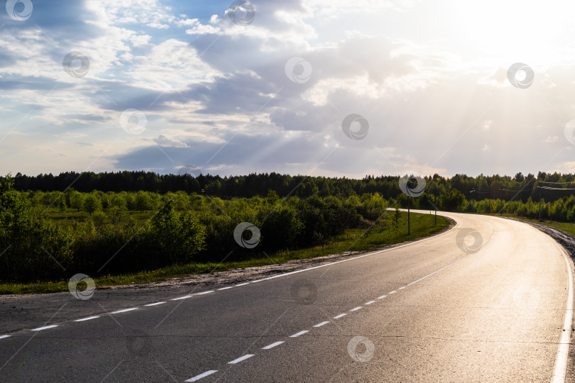 Скачать Залитая солнцем дорога делает резкий поворот. фотосток Ozero