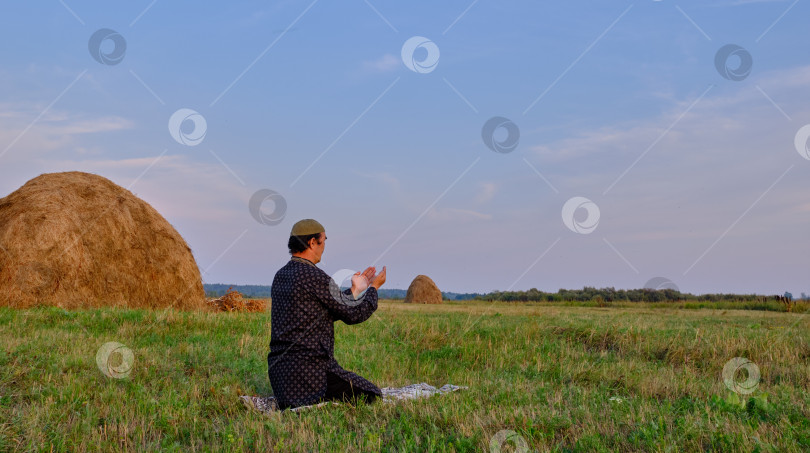 Скачать Пожилой мусульманин молится на сенокосе. фотосток Ozero