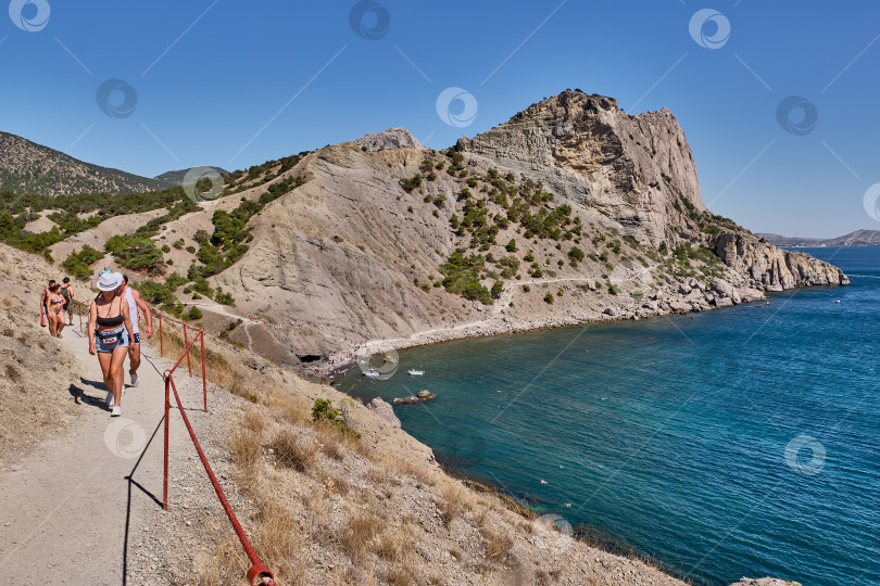 Скачать Крымский полуостров. Люди прогуливаются по туристическому маршруту "Тропа Голицына". Ботанический заповедник "Новый Свет". фотосток Ozero