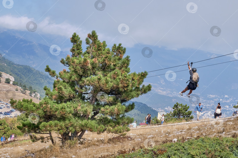 Скачать Жители Южного Крыма прогуливаются по высокогорному плато Ай-Петри, красивая смелая девушка с длинными белыми волосами спускается на троллейбусе фотосток Ozero