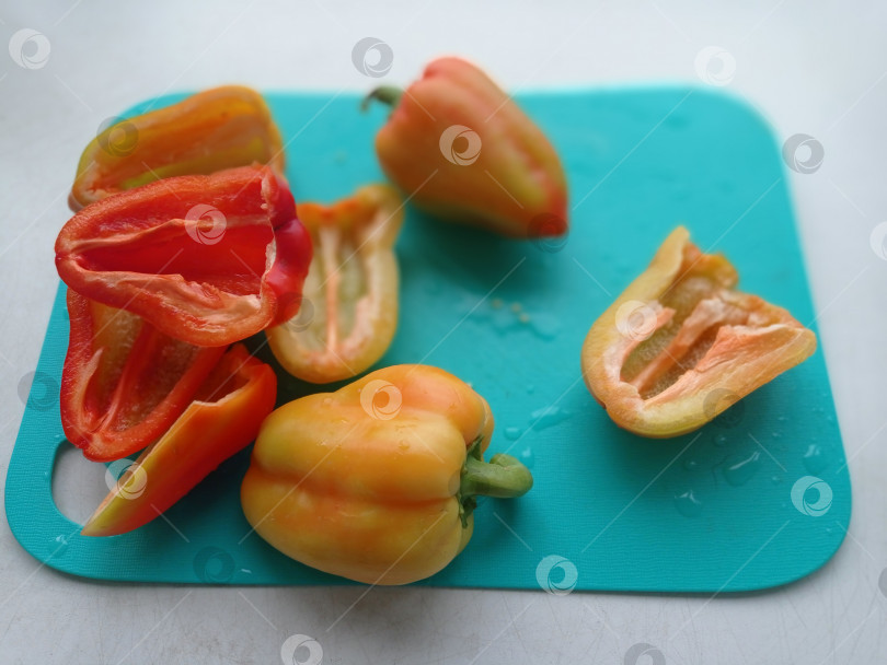 Скачать Плоды сладкого перца на бирюзовой кухонной доске фотосток Ozero
