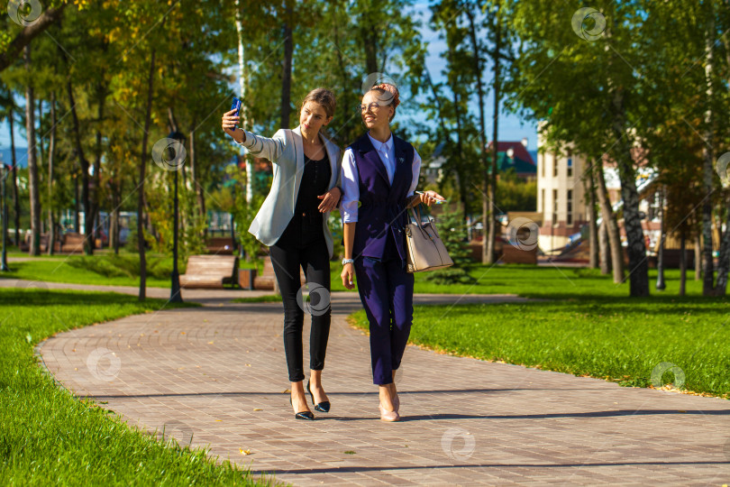 Скачать Две молодые девушки гуляют в летнем парке фотосток Ozero