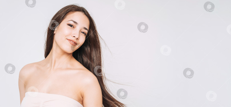 Скачать Красивый портрет счастливой молодой красивой азиатской женщины со здоровыми темными длинными волосами в верхней бандо на белом фоне изолированно фотосток Ozero