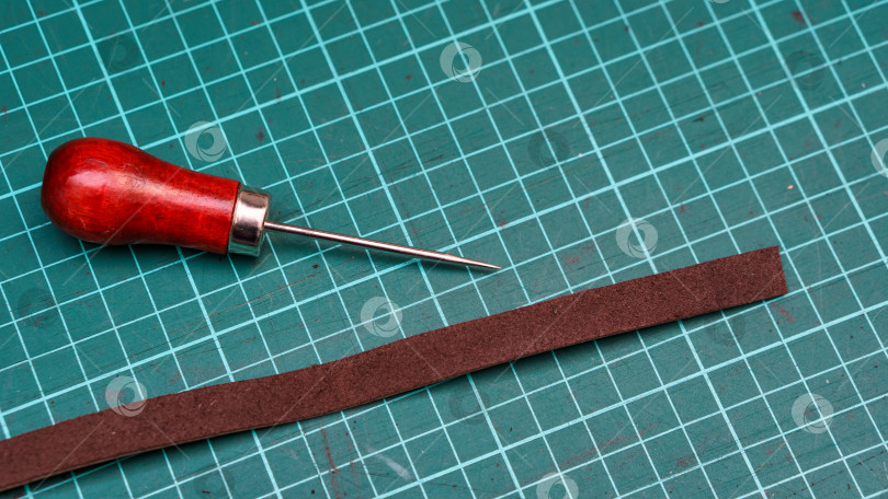 Старое шило при деревянная ручка, изолированная на белой предпосылке