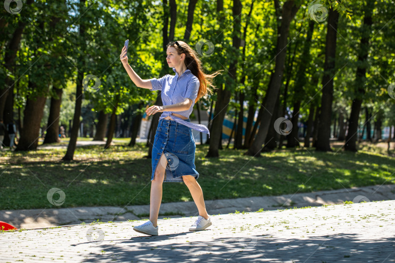 Скачать Молодая девушка в длинной джинсовой юбке, летний парк на открытом воздухе фотосток Ozero