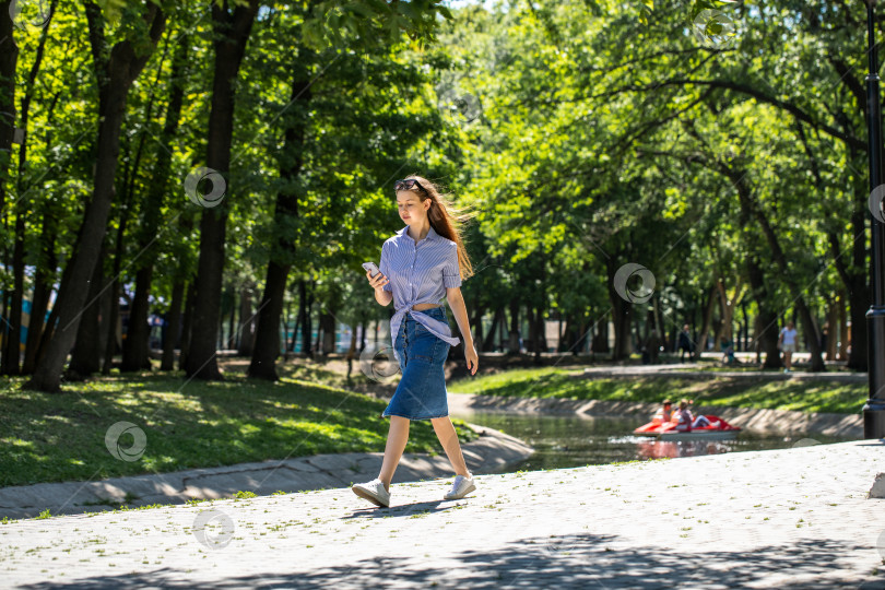 Скачать Молодая девушка в длинной джинсовой юбке, летний парк на открытом воздухе фотосток Ozero