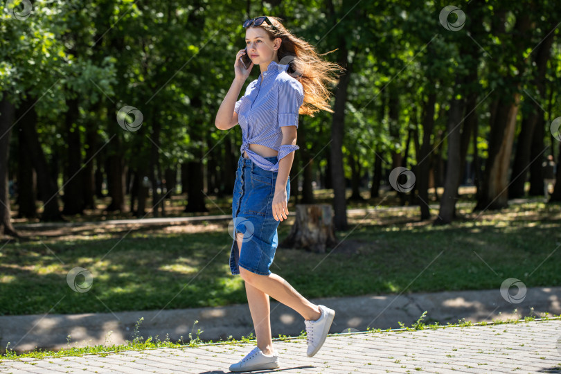 Скачать Молодая девушка в длинной джинсовой юбке, летний парк на открытом воздухе фотосток Ozero