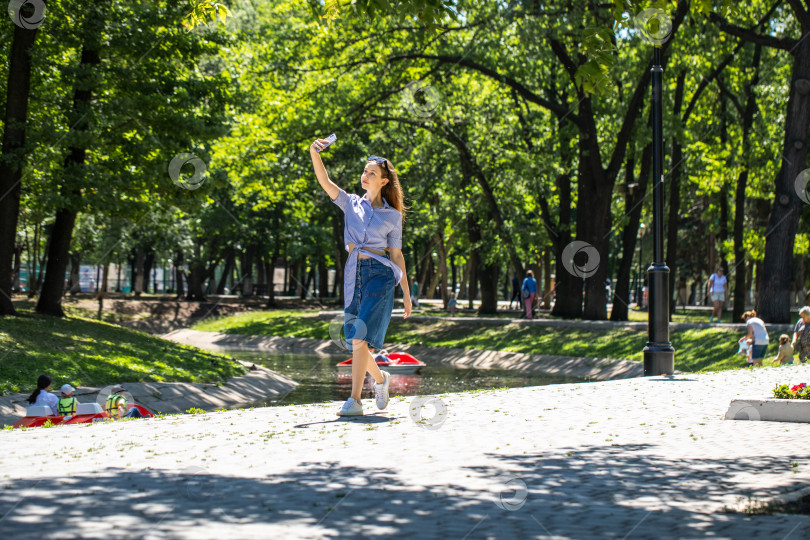 Скачать Молодая девушка в длинной джинсовой юбке, летний парк на открытом воздухе фотосток Ozero