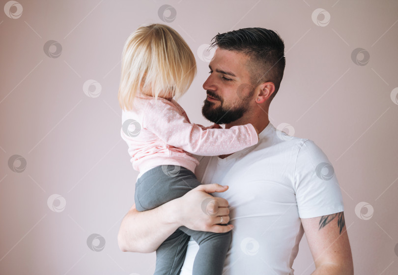 Скачать Молодой отец с маленькой девочкой на руках дома фотосток Ozero