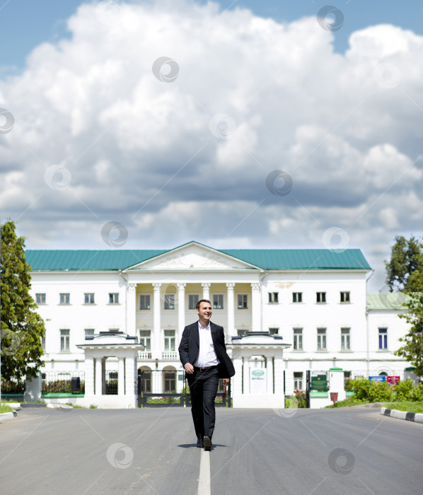 Скачать Портрет молодого бизнесмена в полный рост, идущего по дороге фотосток Ozero