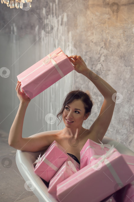 Скачать Девушка сидит в ванне с подарками фотосток Ozero