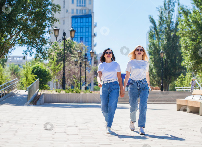 Скачать Две женщины позируют на фоне бизнес-центра фотосток Ozero