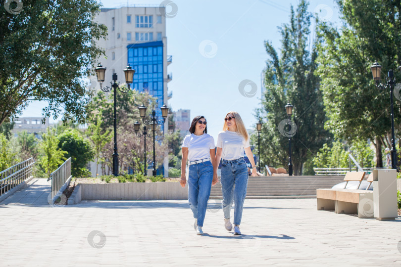 Скачать Две женщины позируют на фоне бизнес-центра фотосток Ozero