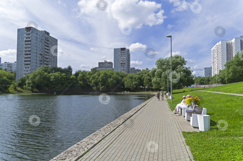 Скачать Люди отдыхают на берегу пруда. фотосток Ozero