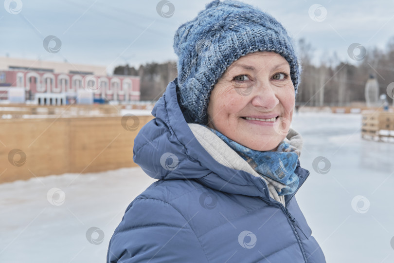 Скачать Портрет пожилой белой женщины крупным планом, улыбающейся и смотрящей в камеру, на катке зимой. фотосток Ozero