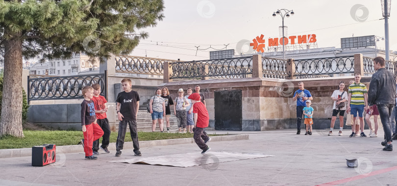 Скачать Мальчики танцуют брейк-данс на городской улице. Прохожие становятся зрителями. фотосток Ozero