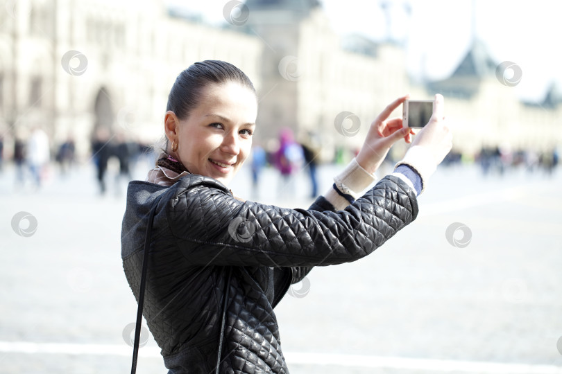 Скачать Молодая женщина фотографирует тебя на телефон фотосток Ozero