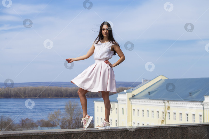 Скачать Молодая брюнетка в розовой юбке и белой блузке фотосток Ozero