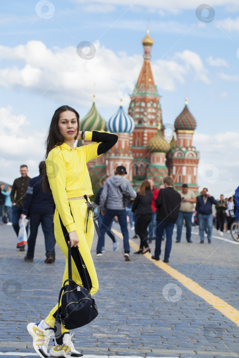 Скачать Портрет молодой красивой брюнетки в желтом спортивном костюме фотосток Ozero