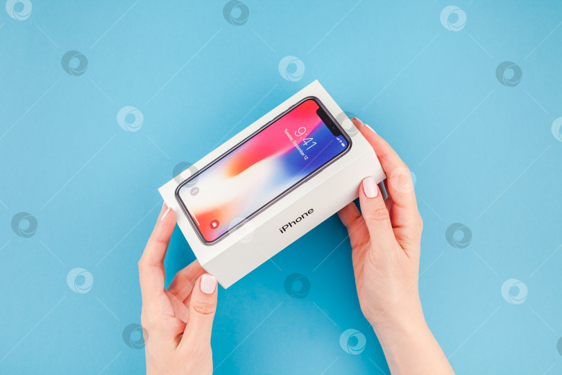 Скачать Женщина протягивает коробку с Apple iPhone X фотосток Ozero